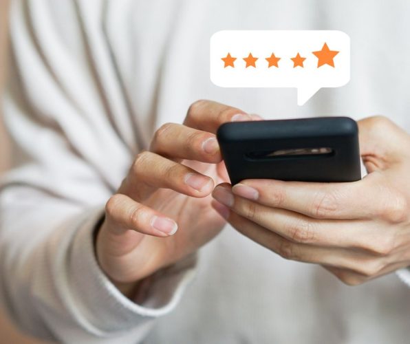 person writing a 5 star review on their mobile