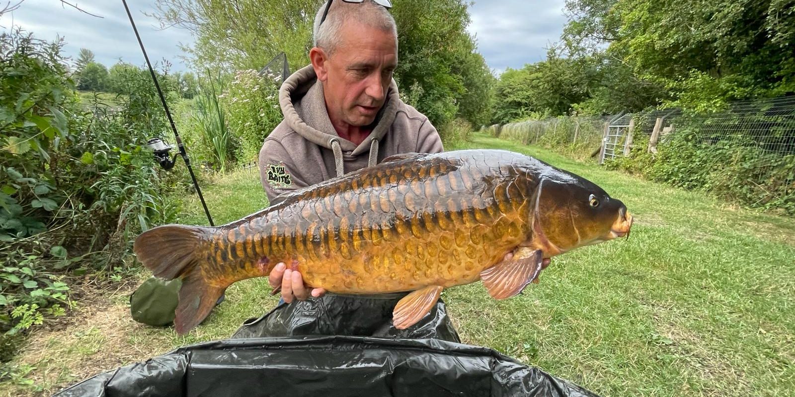 Showing off a huge fish caught in the Cotswold Lakes