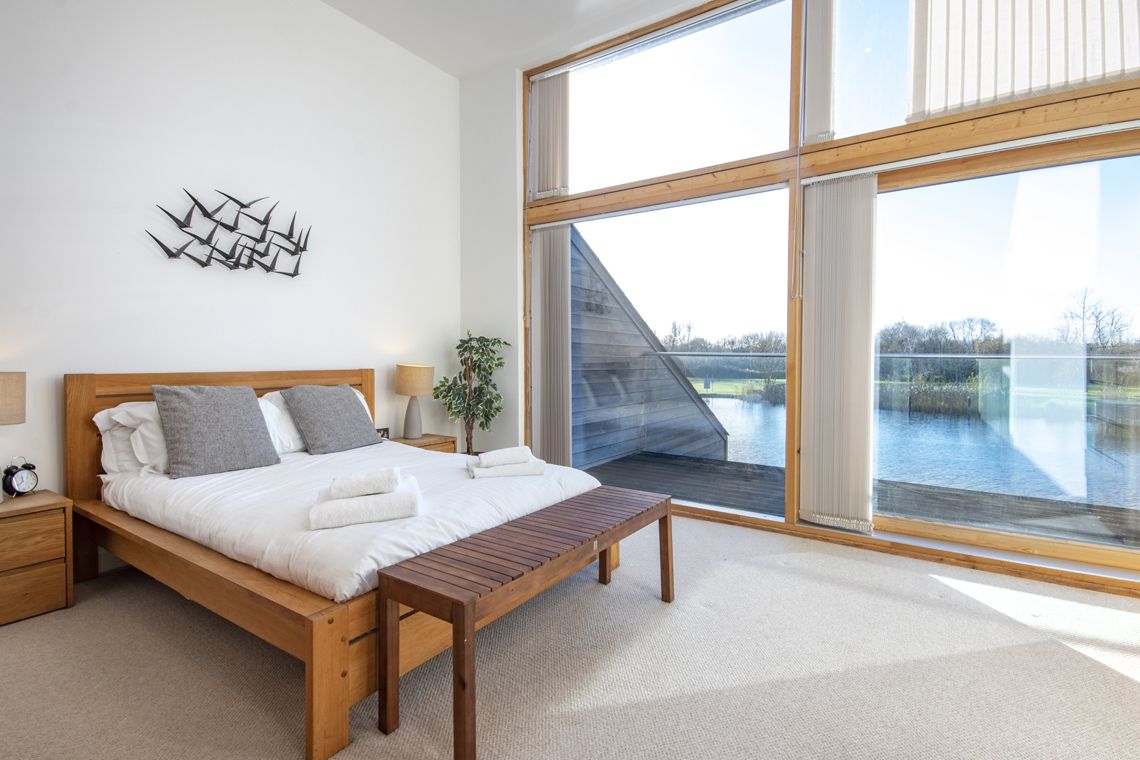 Cropped photo of a Waters Edge bedroom with view out over the lake.